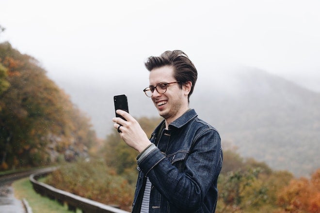 man using small business app on phone along roadside