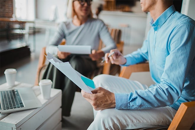 businessman and businesswoman looking over paperwork contracts