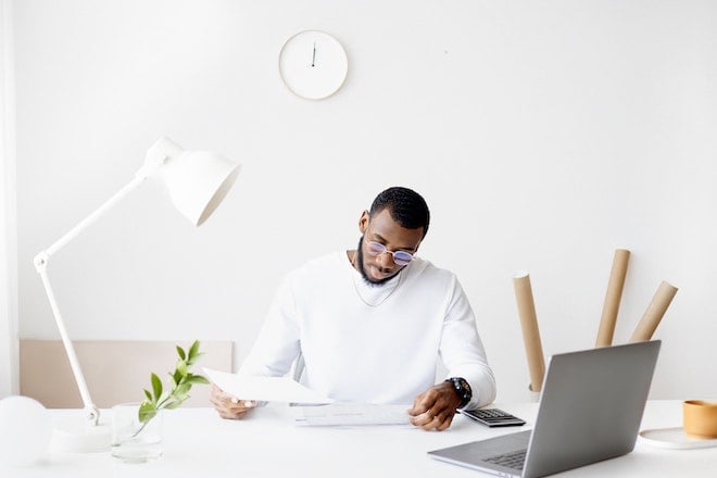 man looking at paperwork at desk