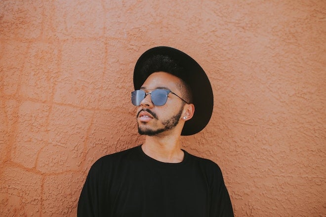 man leaning on brown wall 