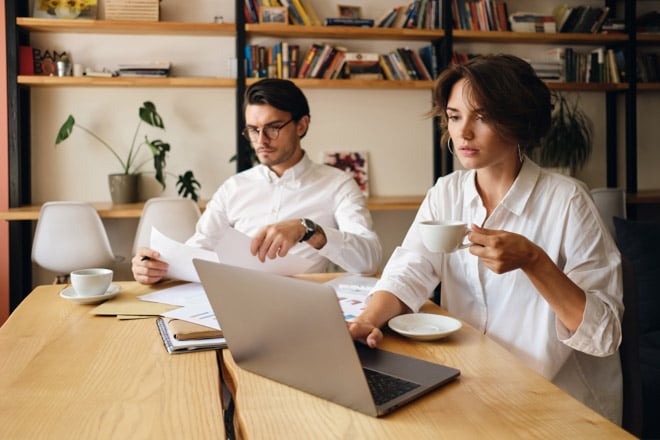 Business colleagues looking at papers and a laptop